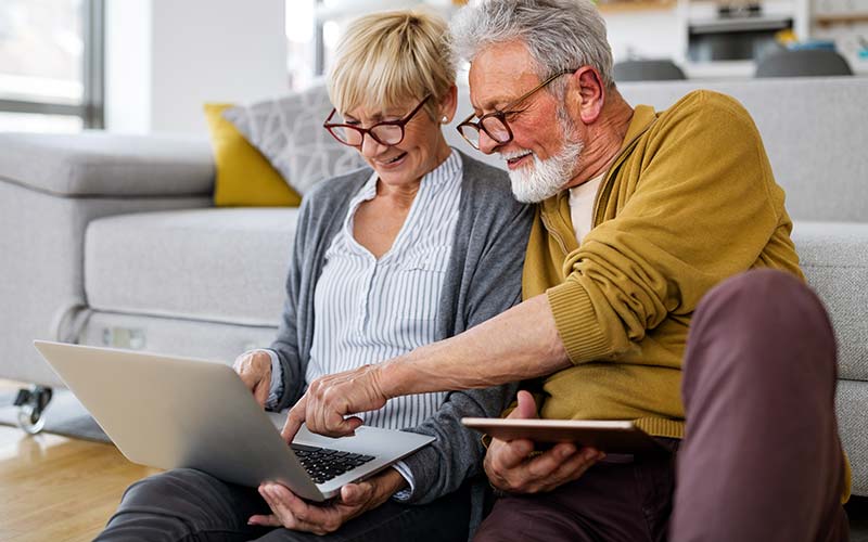 senior couple in their home on laptop going over what real estate agent recommended