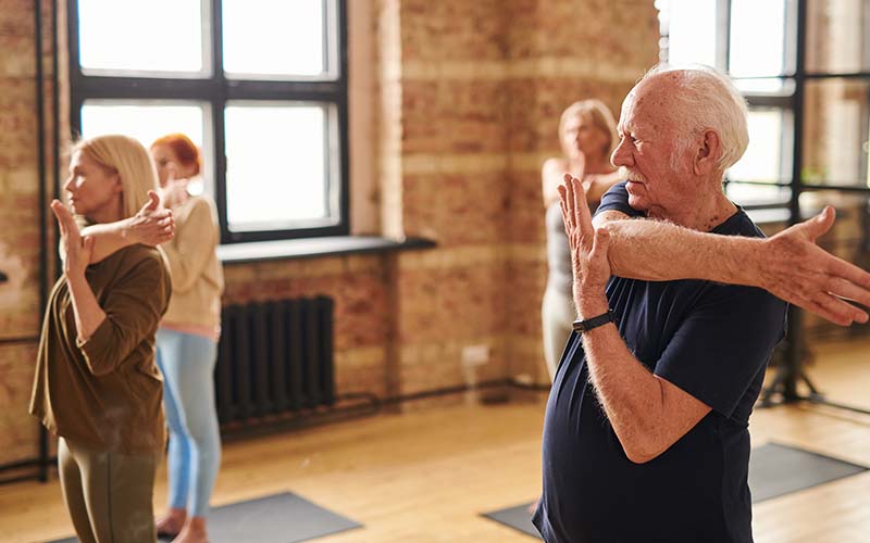 a group of aging people in a workout studio working out