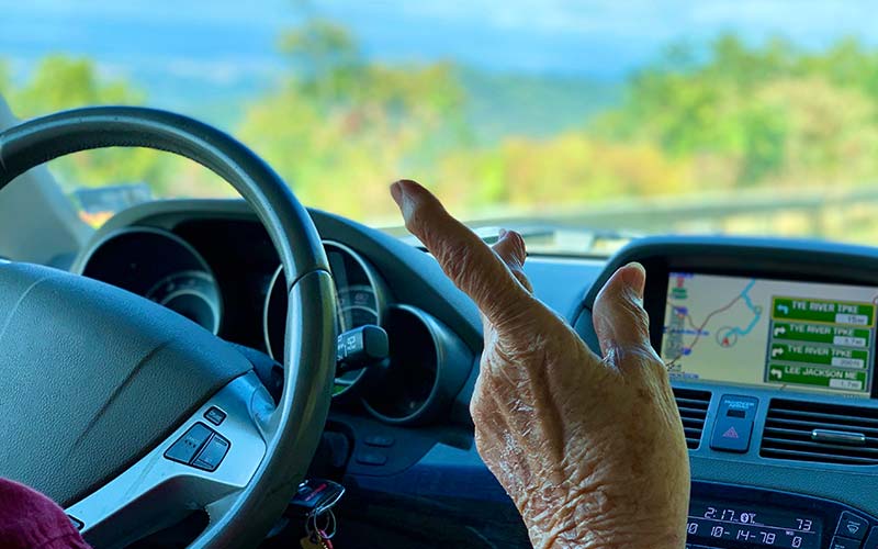 a woman's finger points while dad drives and tries to navigate