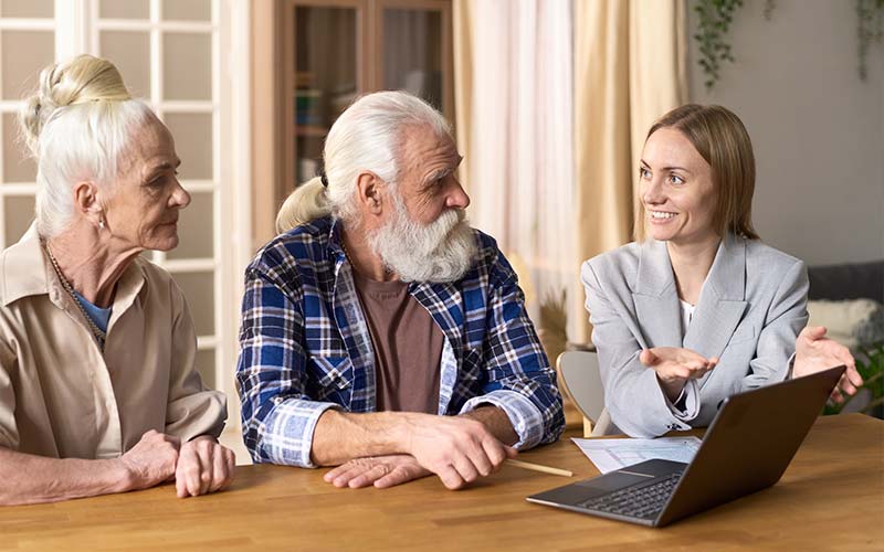 elder law attorney consults with elderly couple at their dining room table