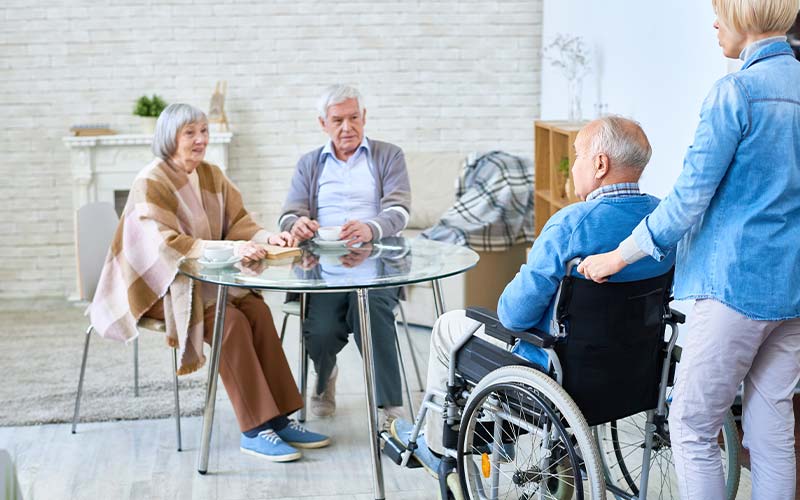 group of seniors at a social table at assisted living facility