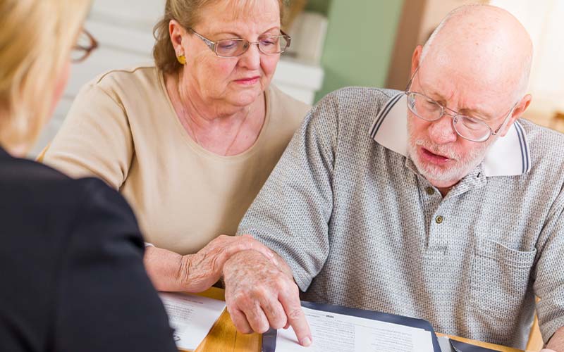 senior couple going over paperwork with an elder law attorney