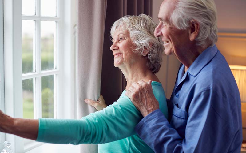 senior couple looks out the window while looking for the right independent living facility