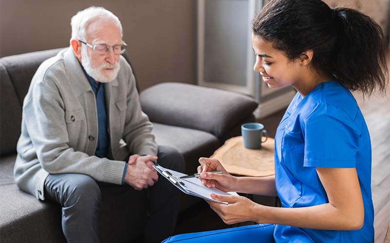 a female geriatric care management nurse assesses an aging adult man