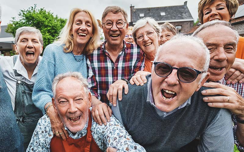 a group of happy energetic seniors taking a group photo together