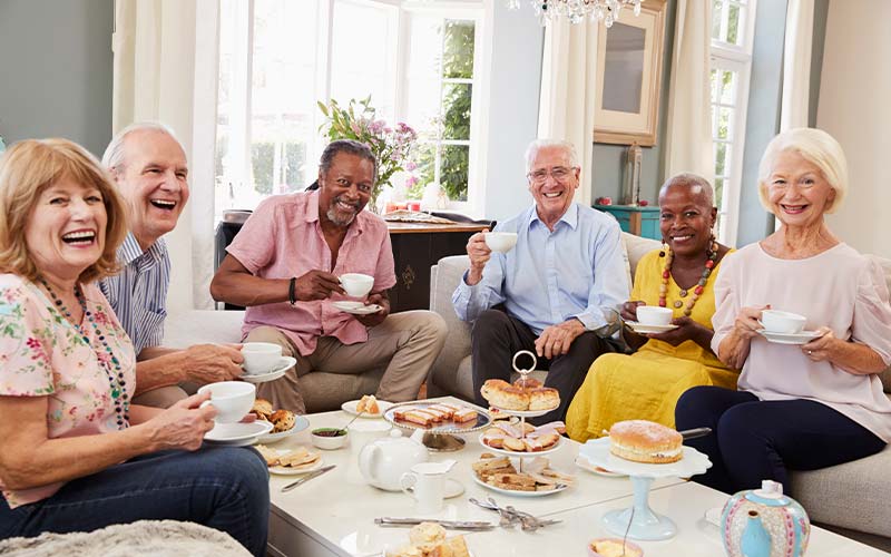 group of seniors socializing having an afternoon tea