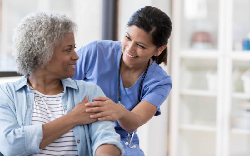 a female nurse cares for an elderly woman and her comfort